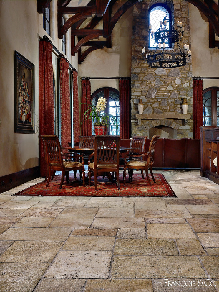 Стильный дизайн: гостиная-столовая среднего размера в стиле рустика с бежевыми стенами, полом из известняка, стандартным камином и фасадом камина из камня - последний тренд