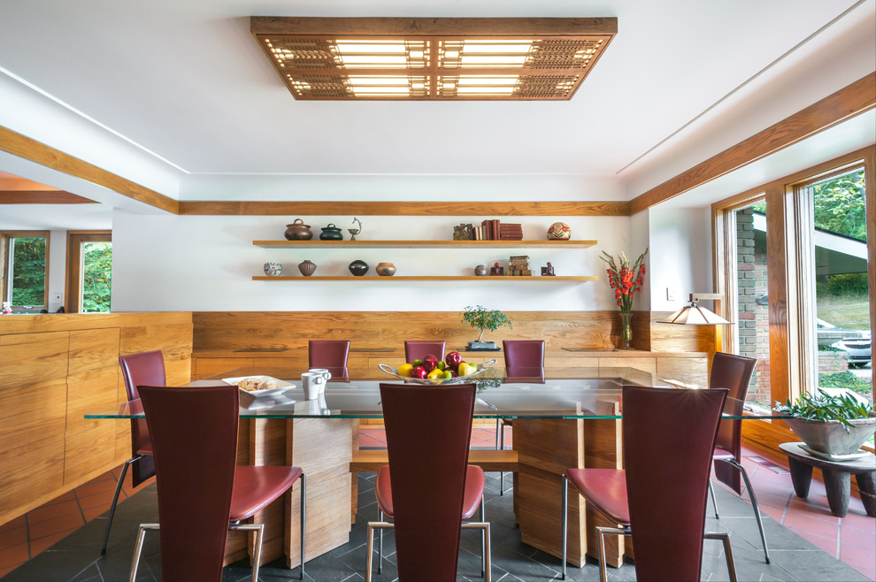 Immagine di una sala da pranzo minimalista con pareti marroni, pavimento in terracotta e pavimento grigio