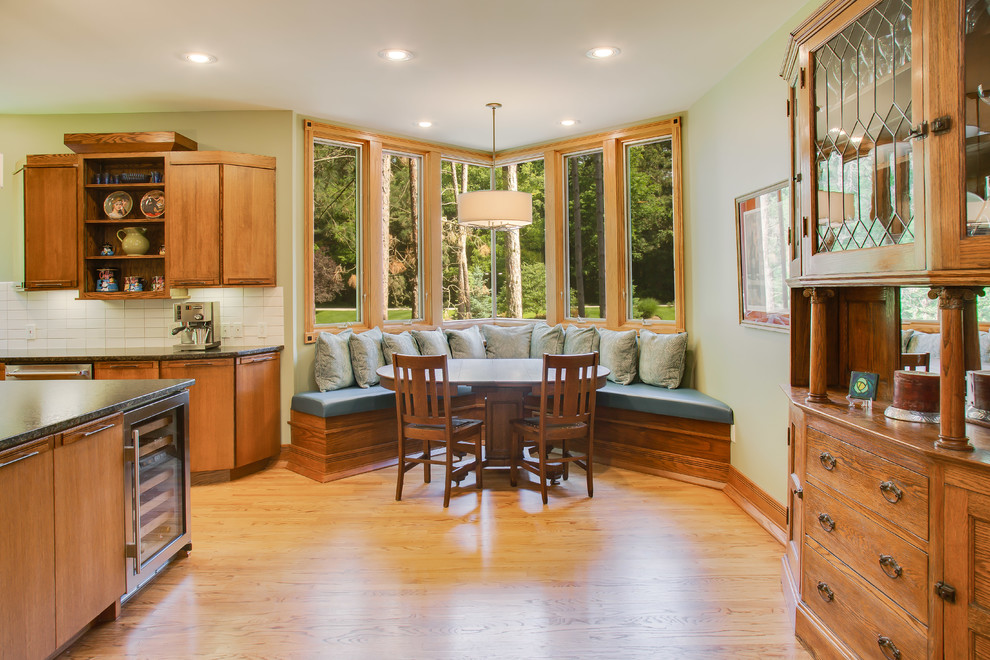 Foto di una grande sala da pranzo aperta verso la cucina stile americano con parquet chiaro e pavimento marrone