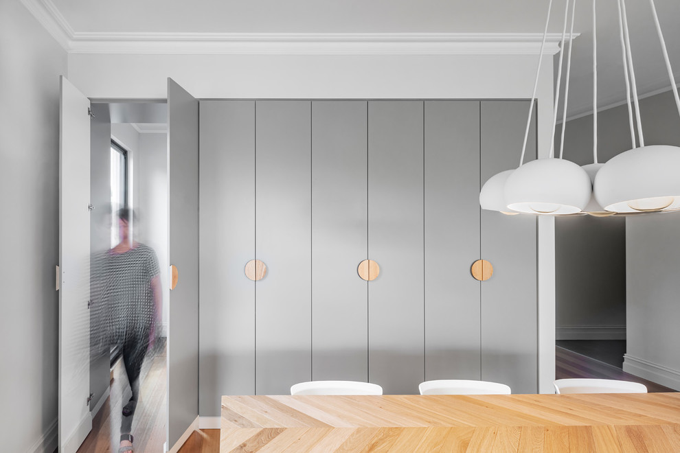 Esempio di una sala da pranzo design con pareti bianche, pavimento in legno massello medio e pavimento marrone