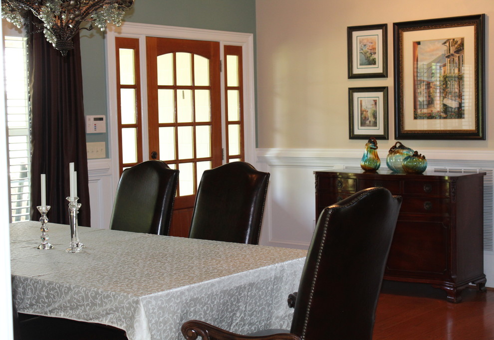 Réalisation d'une grande salle à manger ouverte sur le salon craftsman avec un mur vert, un sol en bois brun et un sol marron.