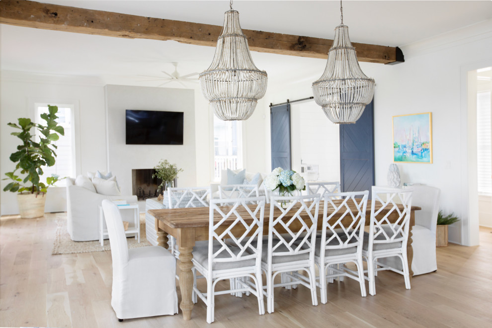 Ispirazione per una sala da pranzo aperta verso il soggiorno stile marinaro con pareti bianche, parquet chiaro, pavimento beige e travi a vista