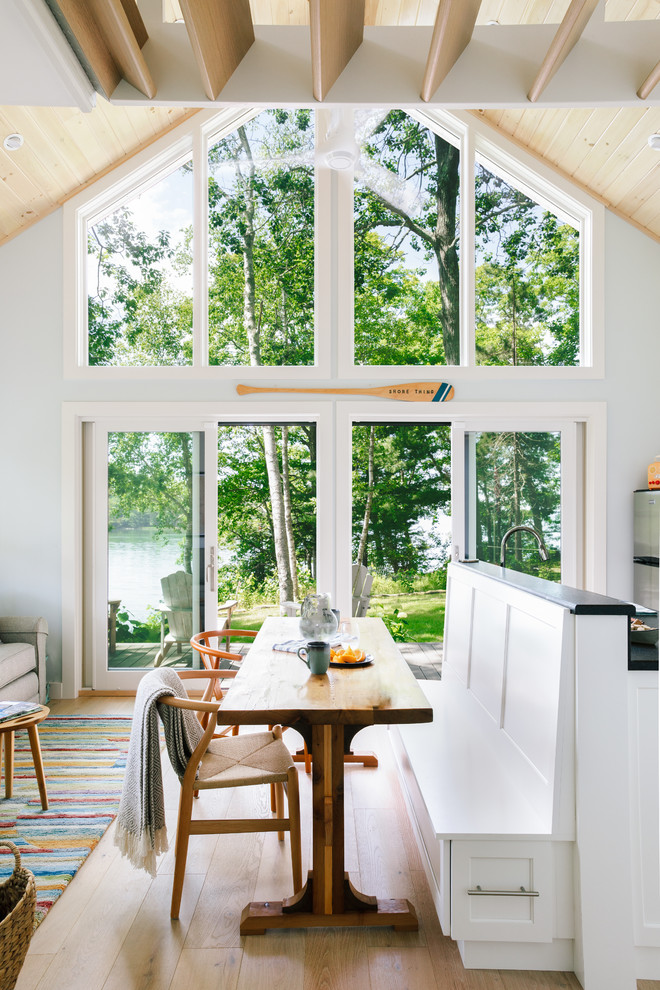 Offenes, Kleines Landhausstil Esszimmer ohne Kamin mit blauer Wandfarbe, hellem Holzboden und braunem Boden in Portland Maine