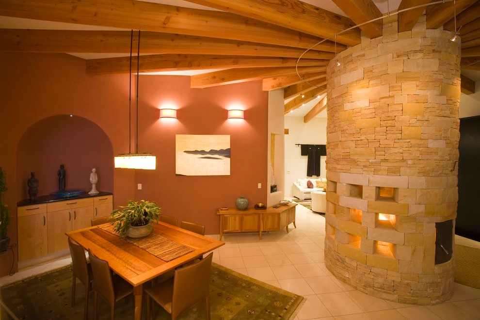 Immagine di una sala da pranzo aperta verso il soggiorno stile americano di medie dimensioni con pareti marroni, pavimento con piastrelle in ceramica, cornice del camino in pietra e pavimento beige