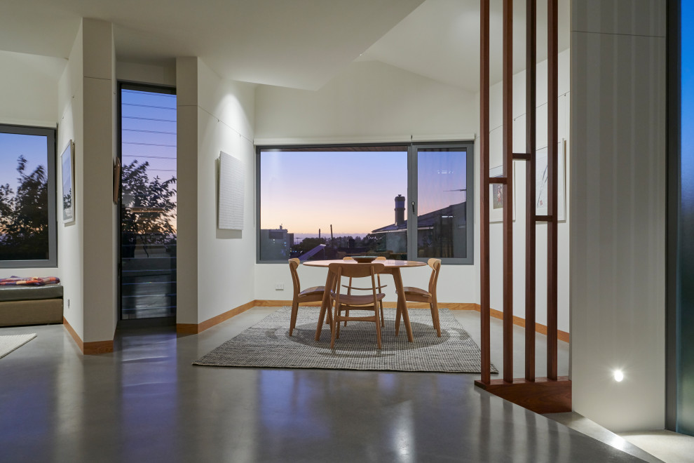 Kleines Modernes Esszimmer mit weißer Wandfarbe, Betonboden und grauem Boden in Perth