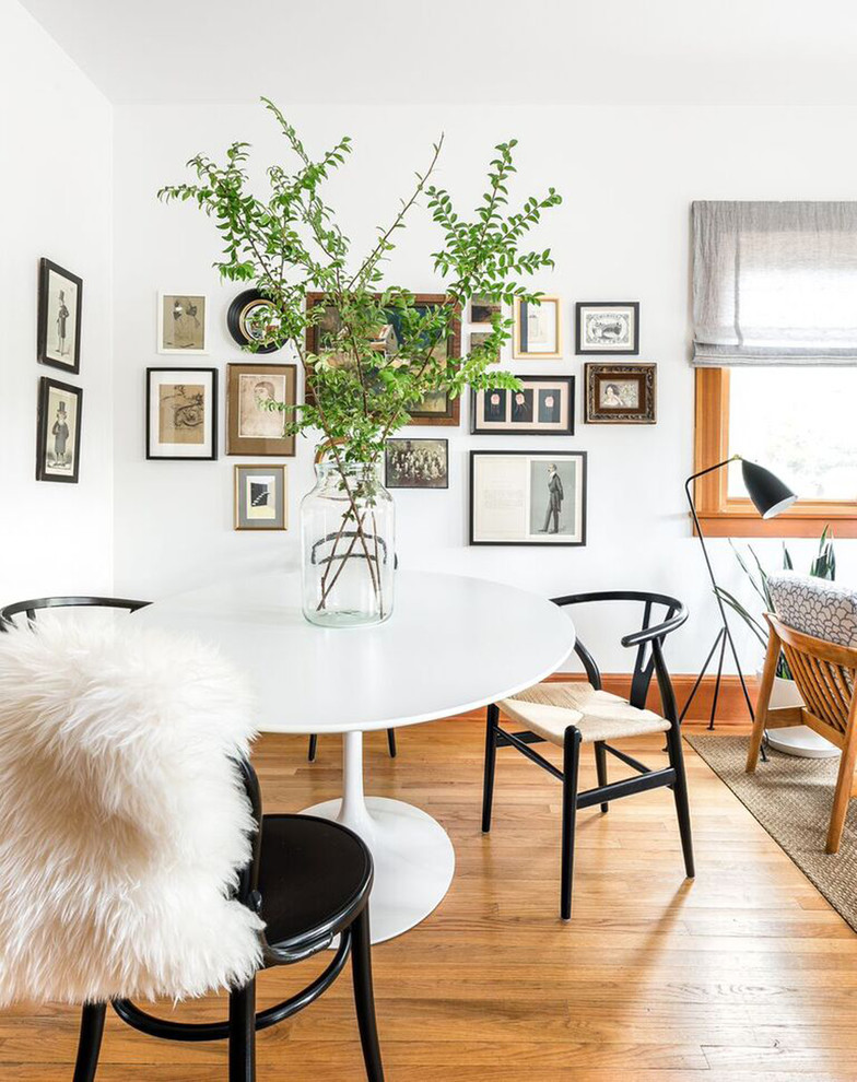 Inspiration pour une salle à manger ouverte sur le salon vintage de taille moyenne avec un mur blanc, parquet clair, aucune cheminée, un sol marron et éclairage.