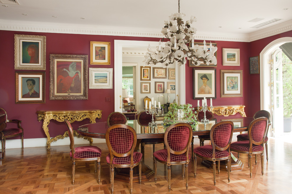 Пример оригинального дизайна: столовая в классическом стиле с красными стенами и паркетным полом среднего тона