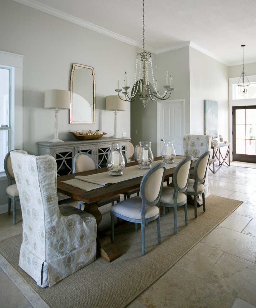 Immagine di una sala da pranzo aperta verso il soggiorno rustica di medie dimensioni con pareti grigie, pavimento in pietra calcarea e pavimento beige