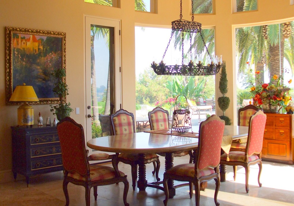 Aménagement d'une salle à manger méditerranéenne de taille moyenne avec une banquette d'angle, un mur jaune, un sol en travertin et un sol beige.