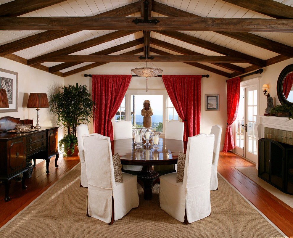 Cette photo montre une salle à manger exotique avec un mur blanc, un sol en bois brun et un manteau de cheminée en carrelage.