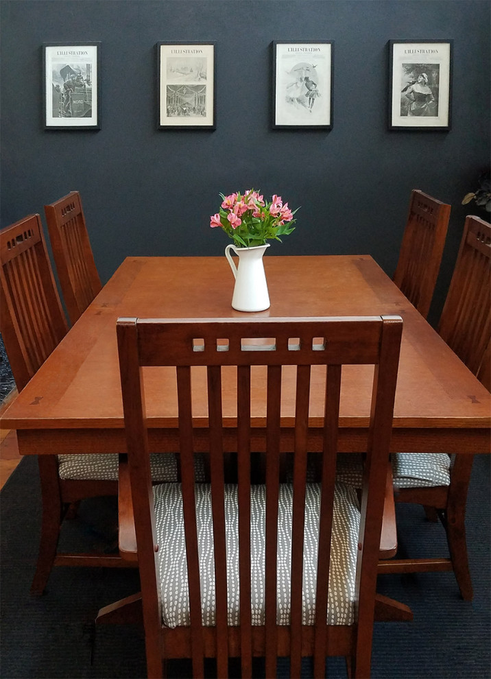 Immagine di una sala da pranzo aperta verso la cucina di medie dimensioni con pareti nere e pavimento nero