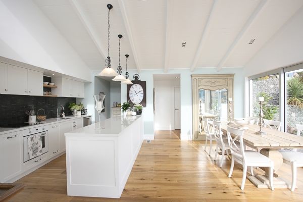 Cette image montre une salle à manger ouverte sur la cuisine traditionnelle de taille moyenne avec un mur blanc, parquet clair, aucune cheminée et un sol beige.