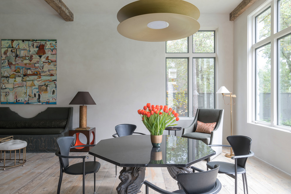 Immagine di una sala da pranzo aperta verso il soggiorno country di medie dimensioni con pareti bianche, parquet chiaro e pavimento beige