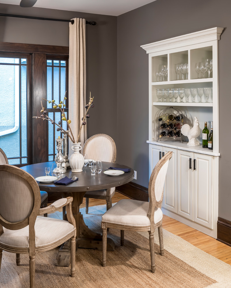 Cette image montre une petite salle à manger ouverte sur la cuisine traditionnelle avec un mur marron et parquet clair.