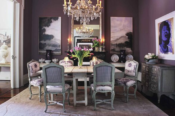 Cette photo montre une salle à manger chic de taille moyenne avec un mur violet, parquet foncé, une cheminée standard, un manteau de cheminée en pierre et un sol marron.