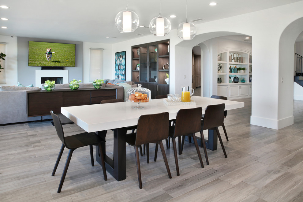 Exemple d'une très grande salle à manger ouverte sur la cuisine tendance avec un mur blanc, un sol gris, un sol en carrelage de porcelaine et une cheminée standard.