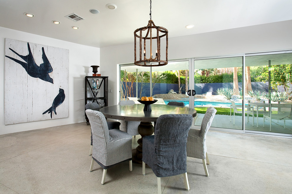Photo of a large contemporary open plan dining room in Los Angeles with white walls and concrete flooring.