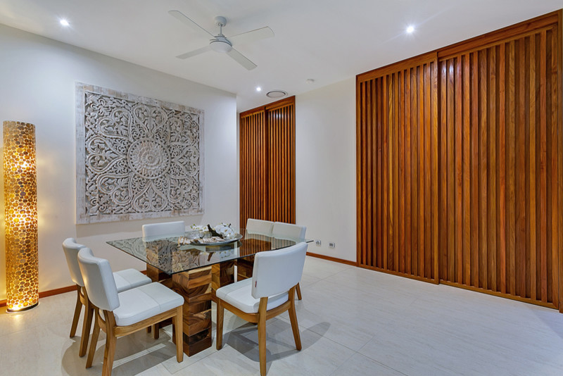Foto di una sala da pranzo aperta verso la cucina tropicale di medie dimensioni con pareti bianche e pavimento in gres porcellanato