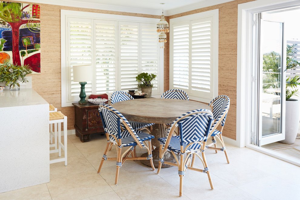 Ispirazione per una piccola sala da pranzo aperta verso la cucina stile marino con pavimento in travertino, pareti marroni e pavimento beige