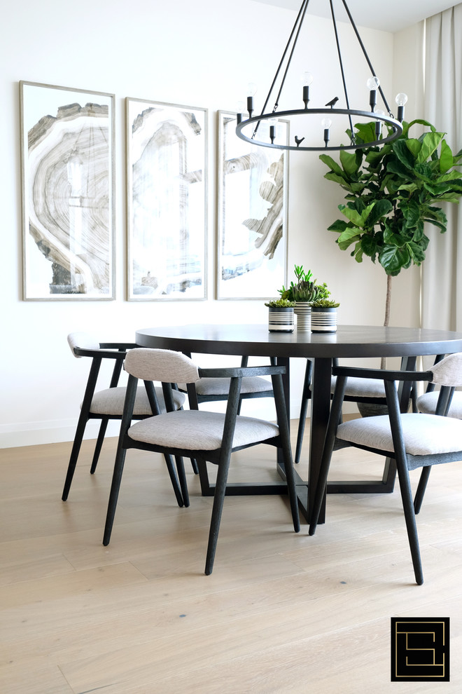 Inspiration for a modern dining room in Toronto with white walls and light hardwood flooring.