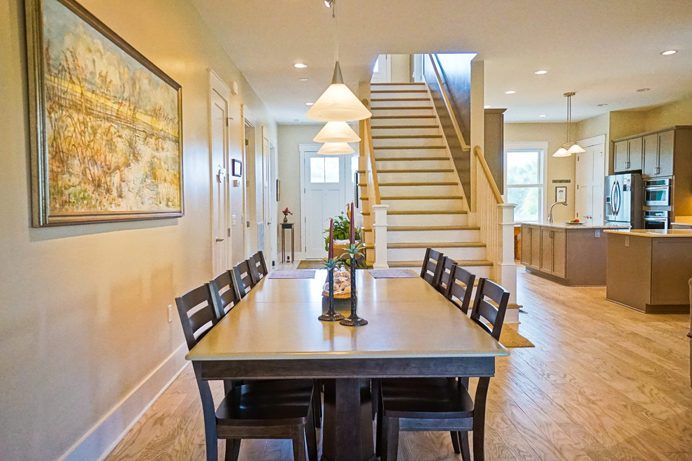 Cette image montre une salle à manger ouverte sur le salon marine de taille moyenne avec un mur beige, parquet clair et aucune cheminée.