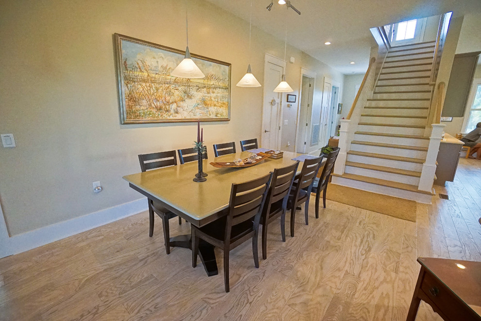 Foto di una sala da pranzo aperta verso il soggiorno stile marinaro di medie dimensioni con pareti beige, parquet chiaro e nessun camino