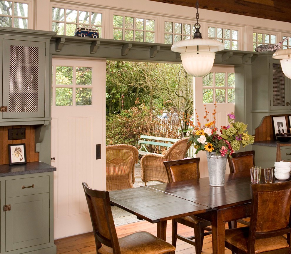 Immagine di una sala da pranzo aperta verso la cucina country con pavimento in legno massello medio
