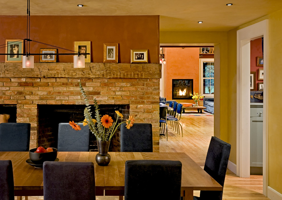 Cette photo montre une salle à manger tendance avec un manteau de cheminée en brique.