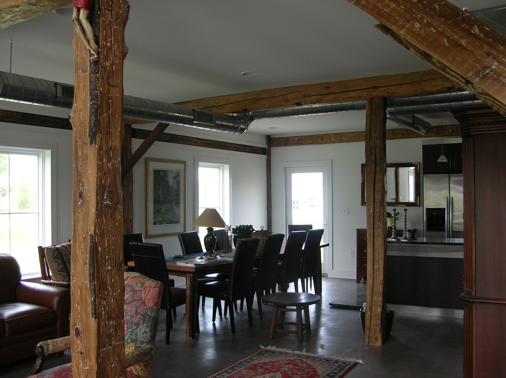 Cette photo montre une salle à manger ouverte sur la cuisine montagne de taille moyenne avec un mur blanc, sol en béton ciré et aucune cheminée.