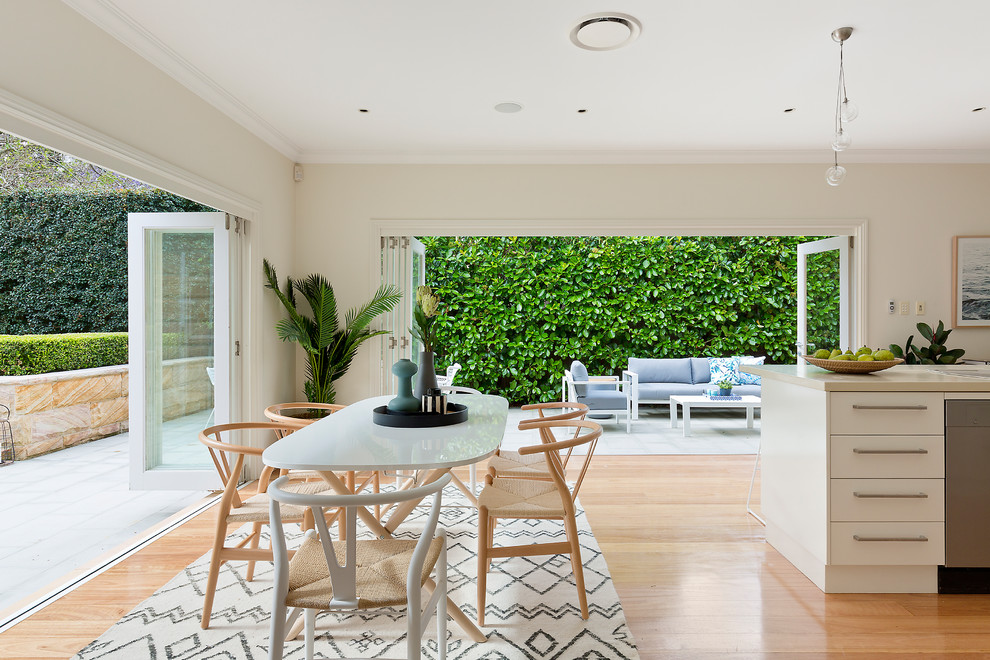 Large coastal open plan dining room in Sydney with beige walls, medium hardwood flooring and brown floors.