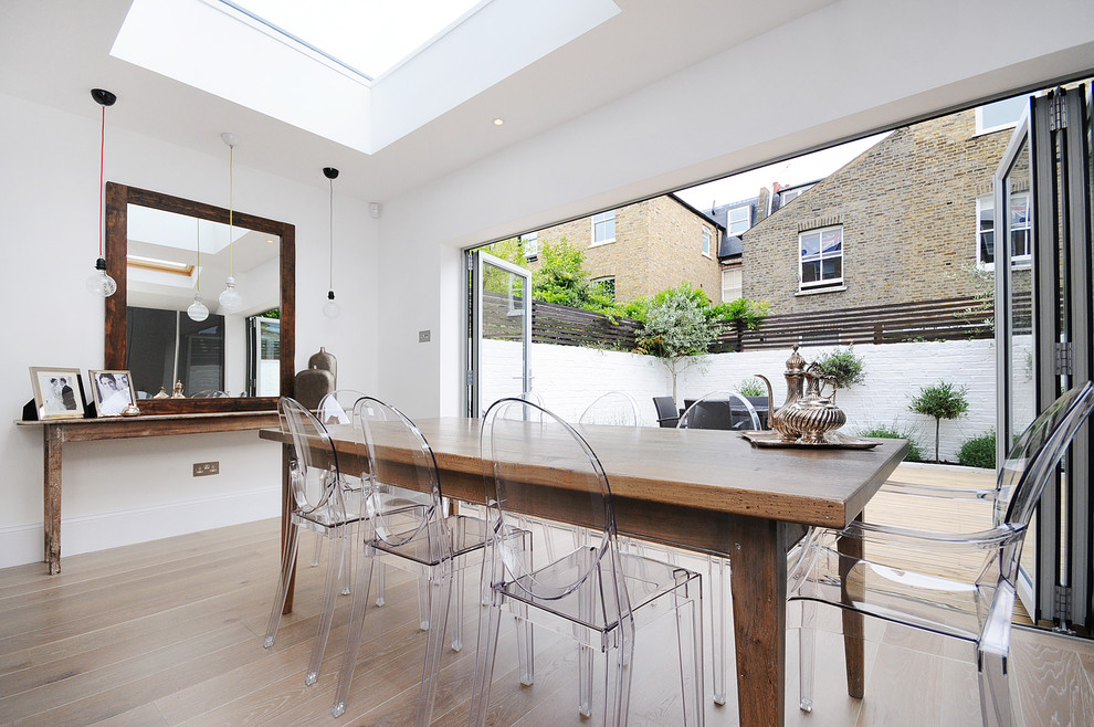 Example of a trendy dining room design in London with white walls