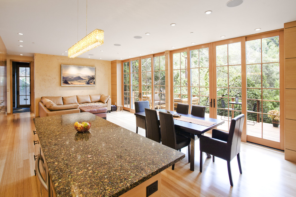 Foto di una sala da pranzo aperta verso il soggiorno minimal con pareti beige e pavimento in legno massello medio