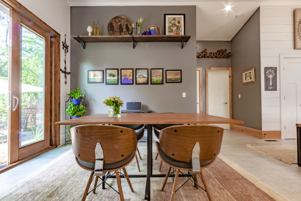 Immagine di una sala da pranzo aperta verso la cucina bohémian di medie dimensioni con pareti grigie, pavimento in laminato, nessun camino e pavimento grigio