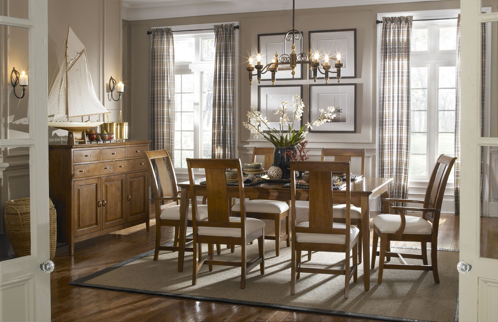 This is an example of an eclectic dining room in Charlotte with brown walls and medium hardwood flooring.