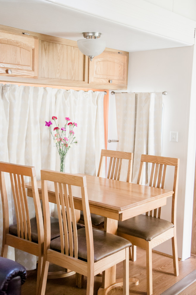 Immagine di una piccola sala da pranzo aperta verso il soggiorno bohémian con pareti arancioni