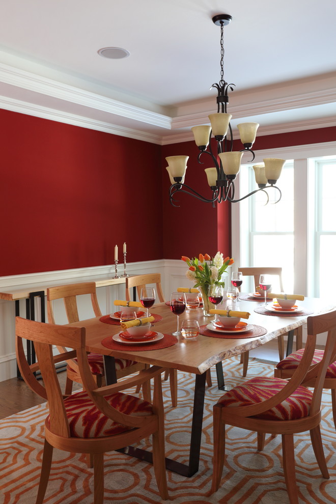 Réalisation d'une salle à manger ouverte sur la cuisine design de taille moyenne avec un mur rouge, parquet clair et aucune cheminée.