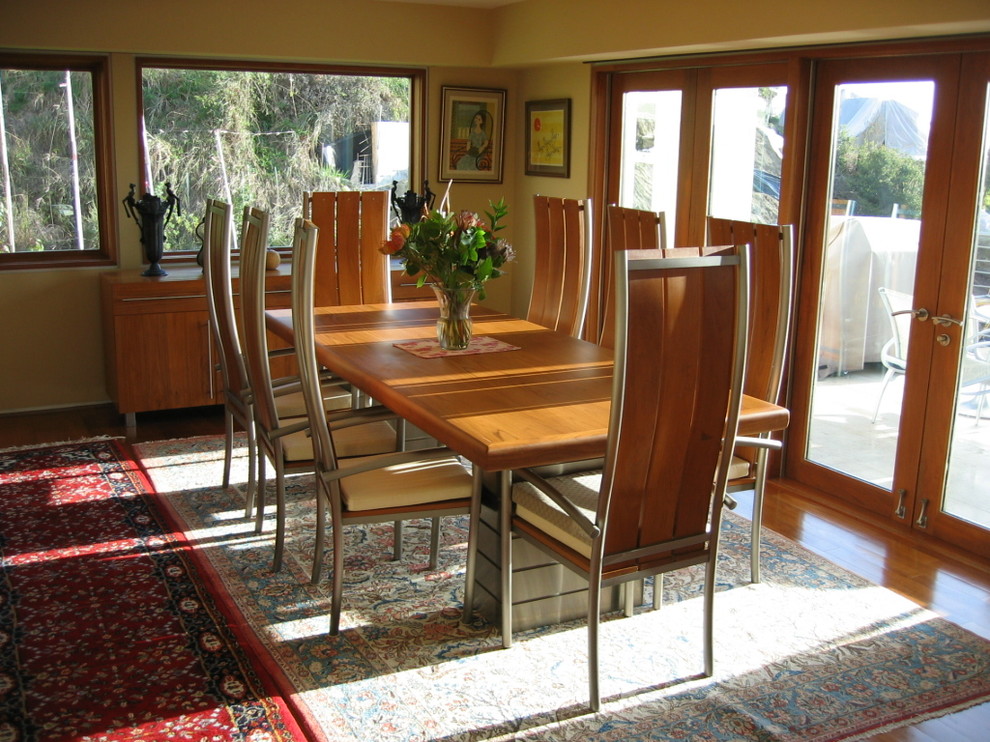 Ispirazione per una sala da pranzo contemporanea con pareti gialle e pavimento in legno massello medio