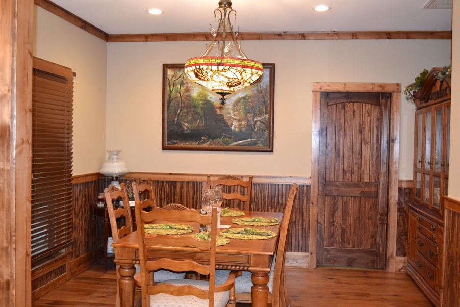 Esempio di una piccola sala da pranzo aperta verso la cucina stile rurale con pareti beige, pavimento in legno massello medio e nessun camino