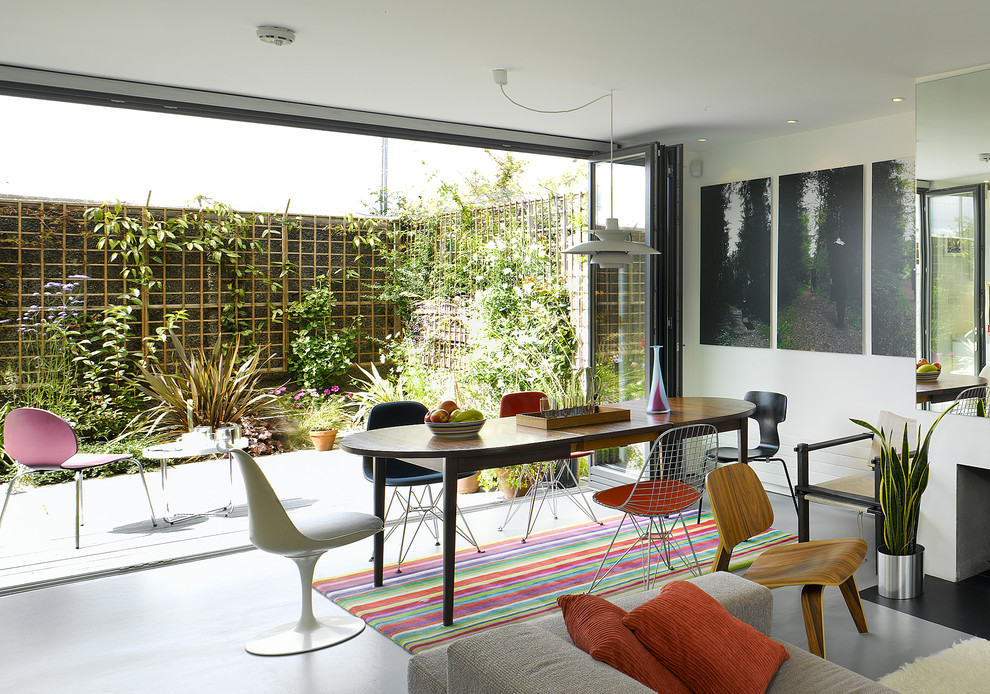 This is an example of a medium sized contemporary open plan dining room in Dublin with white walls and a standard fireplace.
