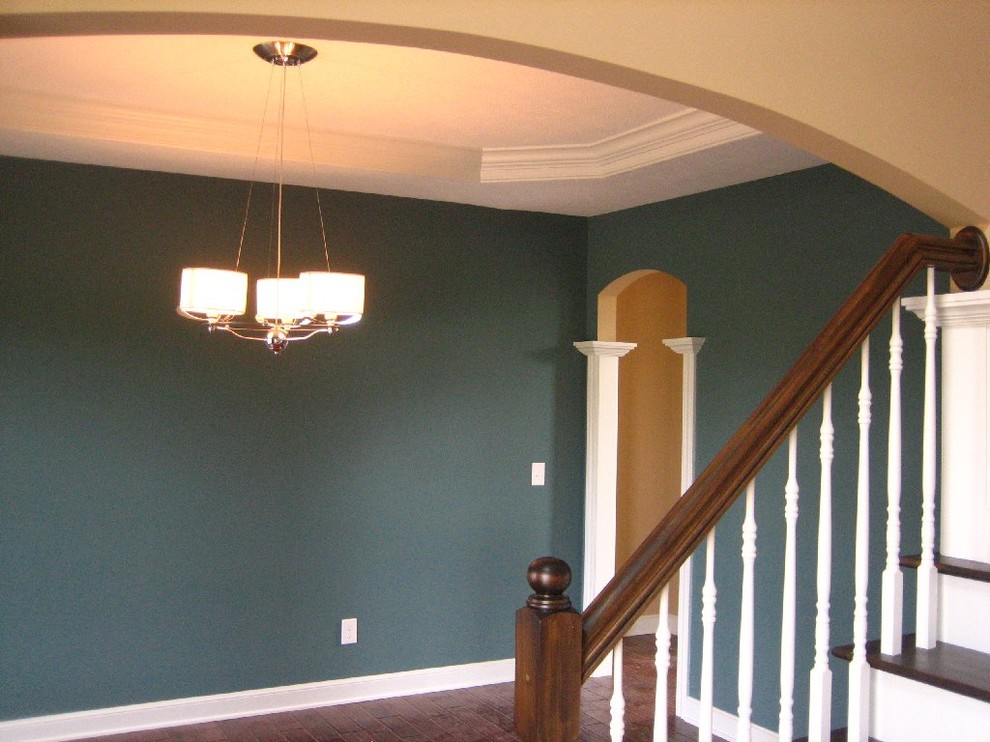 Offenes Klassisches Esszimmer mit grüner Wandfarbe und dunklem Holzboden in Cleveland