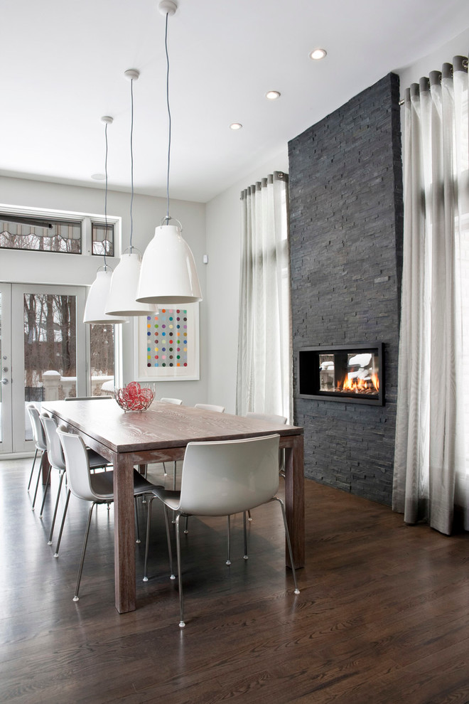 Inspiration for a contemporary dining room in Montreal with a ribbon fireplace.
