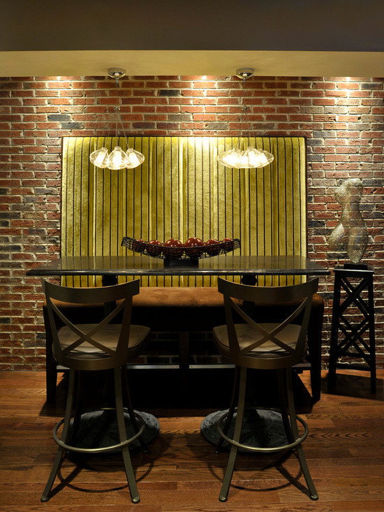 Idée de décoration pour une salle à manger design fermée et de taille moyenne avec un mur rouge, un sol en brique et un sol marron.