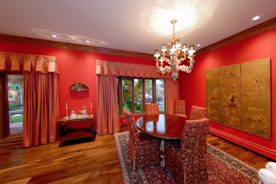 Large world-inspired dining room in Denver with red walls and light hardwood flooring.