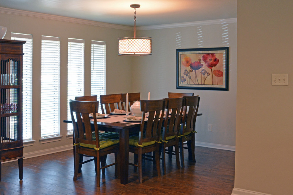 Cette photo montre une salle à manger ouverte sur la cuisine tendance de taille moyenne avec un mur beige, un sol en bois brun, une cheminée standard et un manteau de cheminée en pierre.