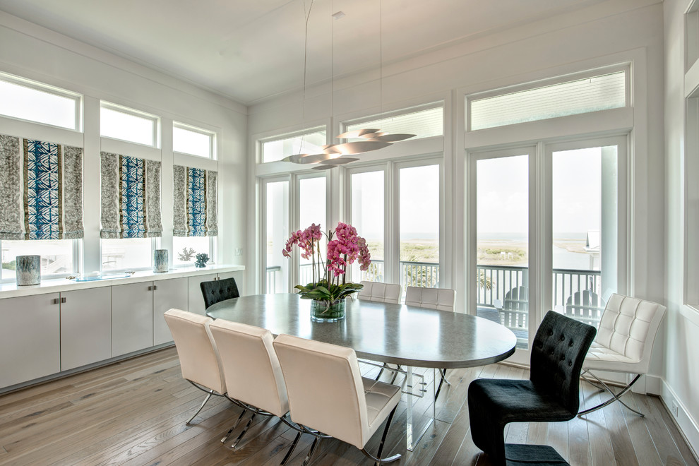 Inspiration for a coastal medium tone wood floor and brown floor dining room remodel in Houston with white walls