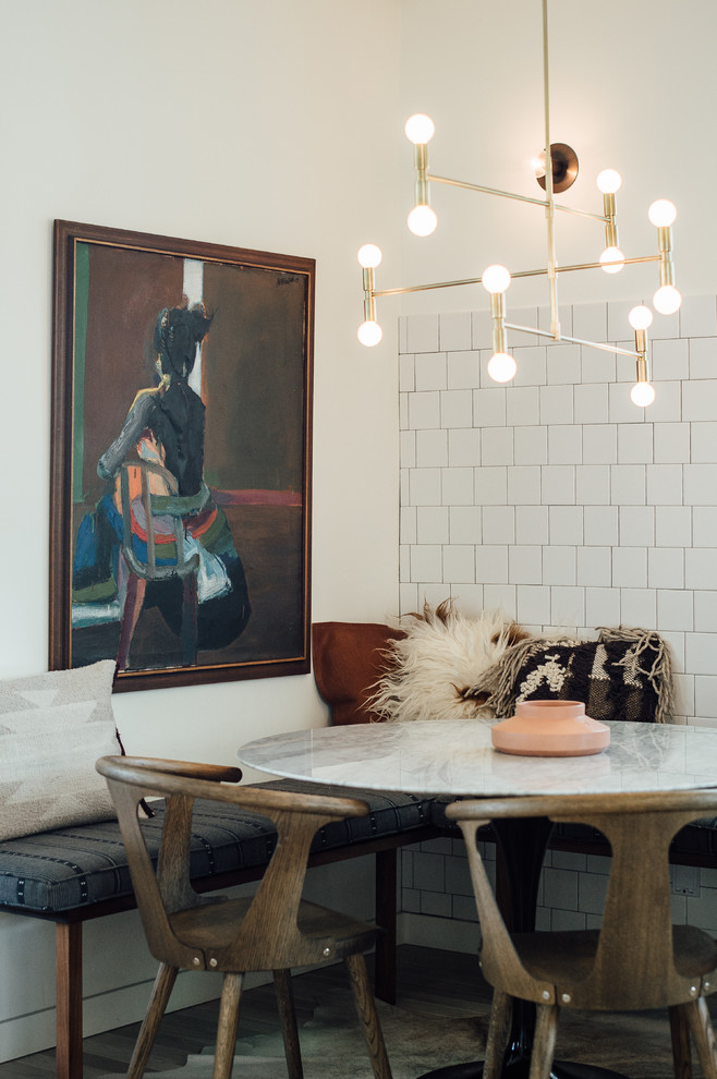 Ispirazione per una piccola sala da pranzo aperta verso la cucina eclettica con pareti bianche e parquet chiaro
