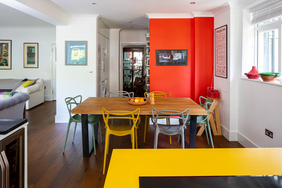 На фото: гостиная-столовая среднего размера в стиле фьюжн с красными стенами, темным паркетным полом и коричневым полом без камина