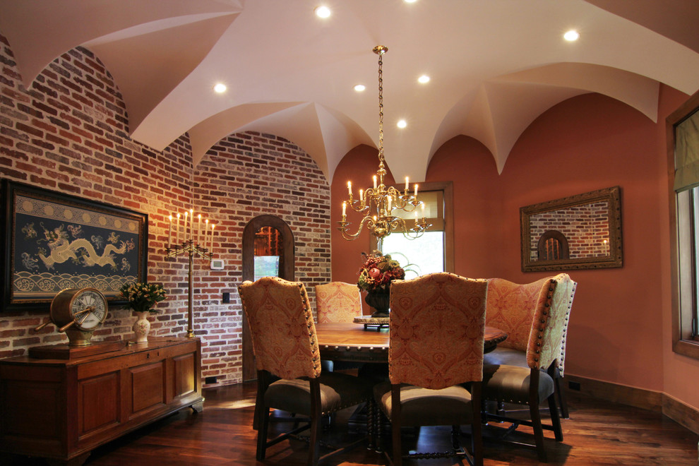 Immagine di una sala da pranzo aperta verso la cucina mediterranea di medie dimensioni con pareti arancioni e parquet scuro