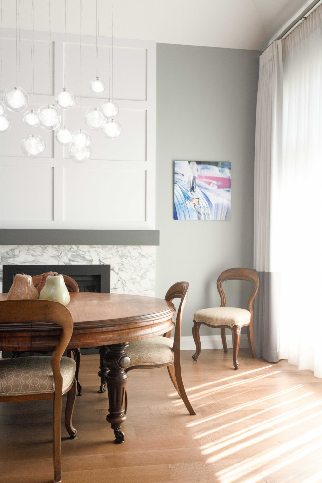 Offenes, Mittelgroßes Modernes Esszimmer mit weißer Wandfarbe, Kamin, gewölbter Decke, Wandpaneelen, Kaminumrandung aus Stein und braunem Boden in Vancouver