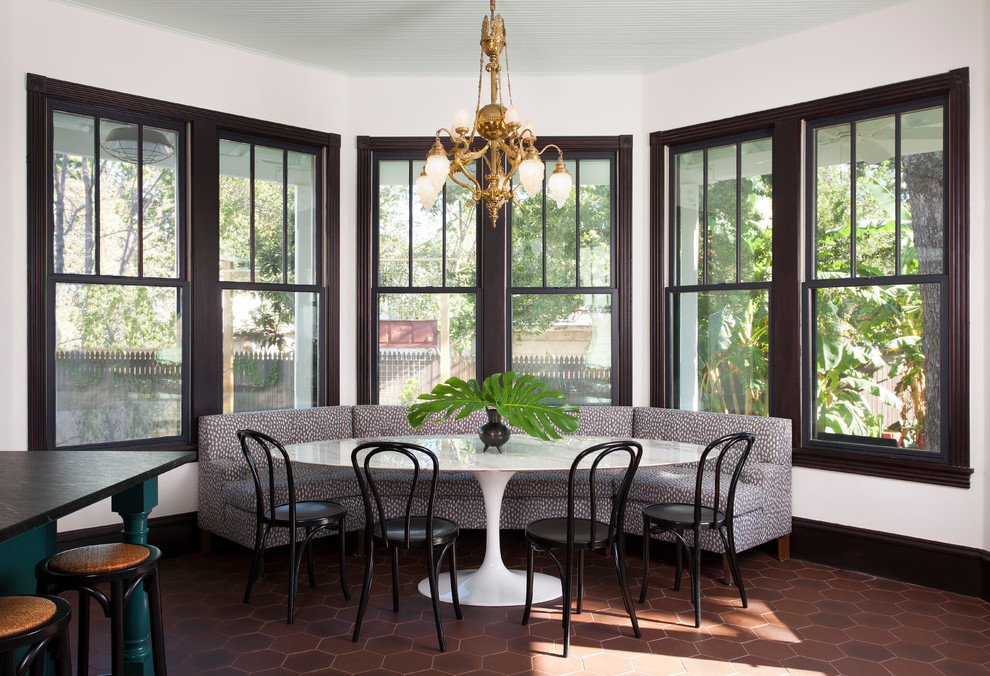 Bohemian kitchen/dining room in Austin with white walls, brown floors and no fireplace.